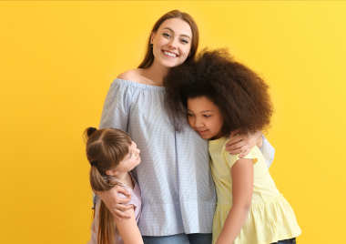 three firls smiling and hugging