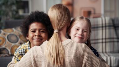 Carer hugging children