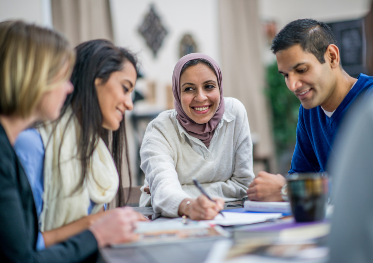 four people working together at a table